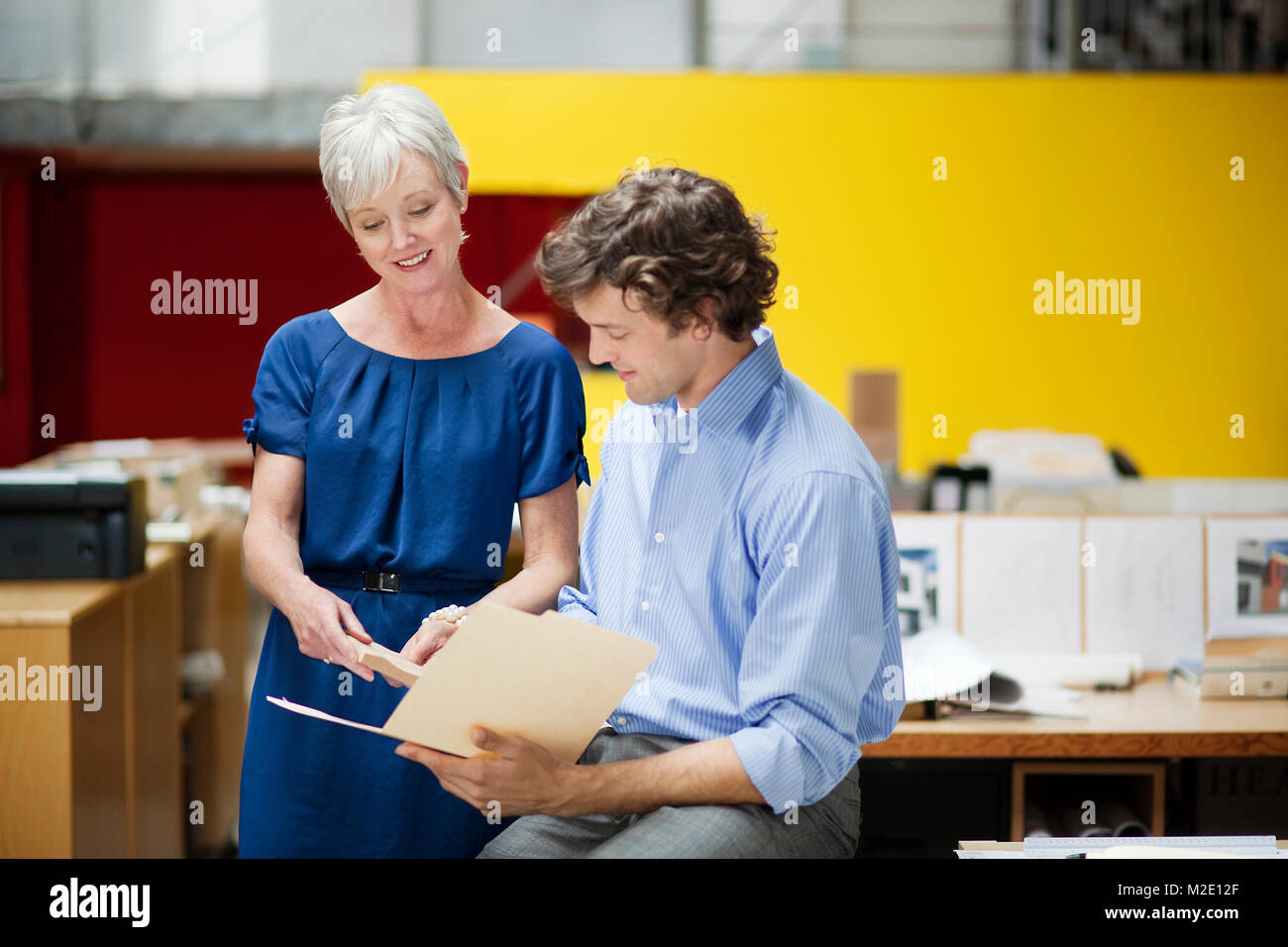 Business people reading file folder in office Stock Photo