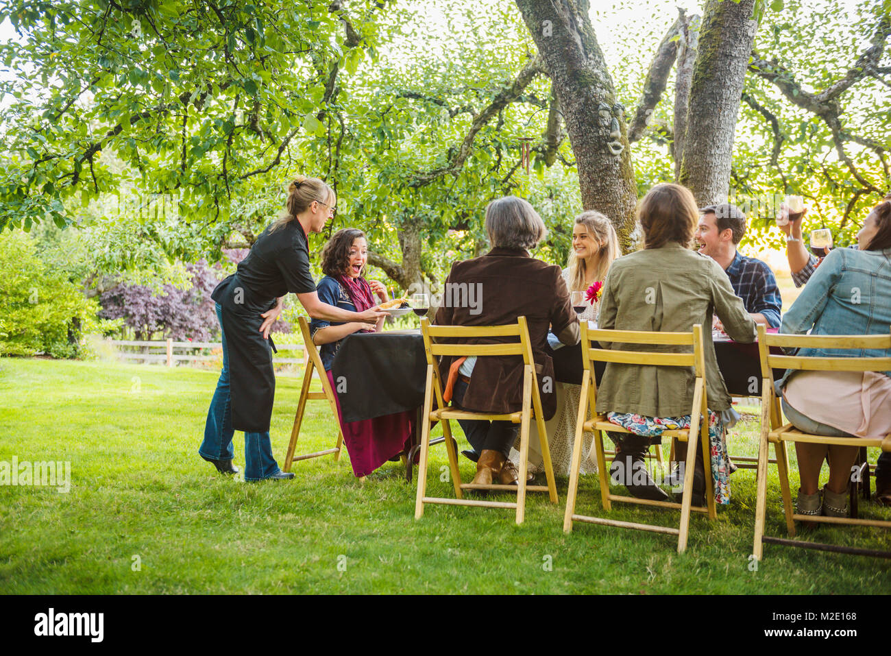 Friends enjoying wine at party outdoors Stock Photo