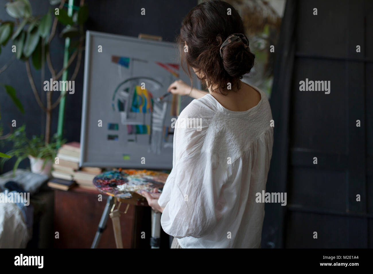 Rear view of Caucasian woman painting on easel Stock Photo - Alamy