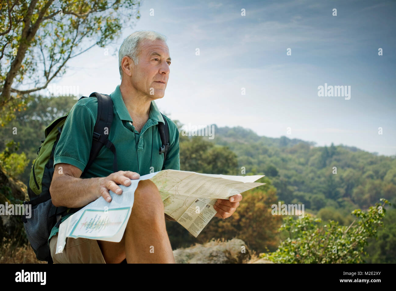 Caucasian man hiking and reading map Stock Photo - Alamy