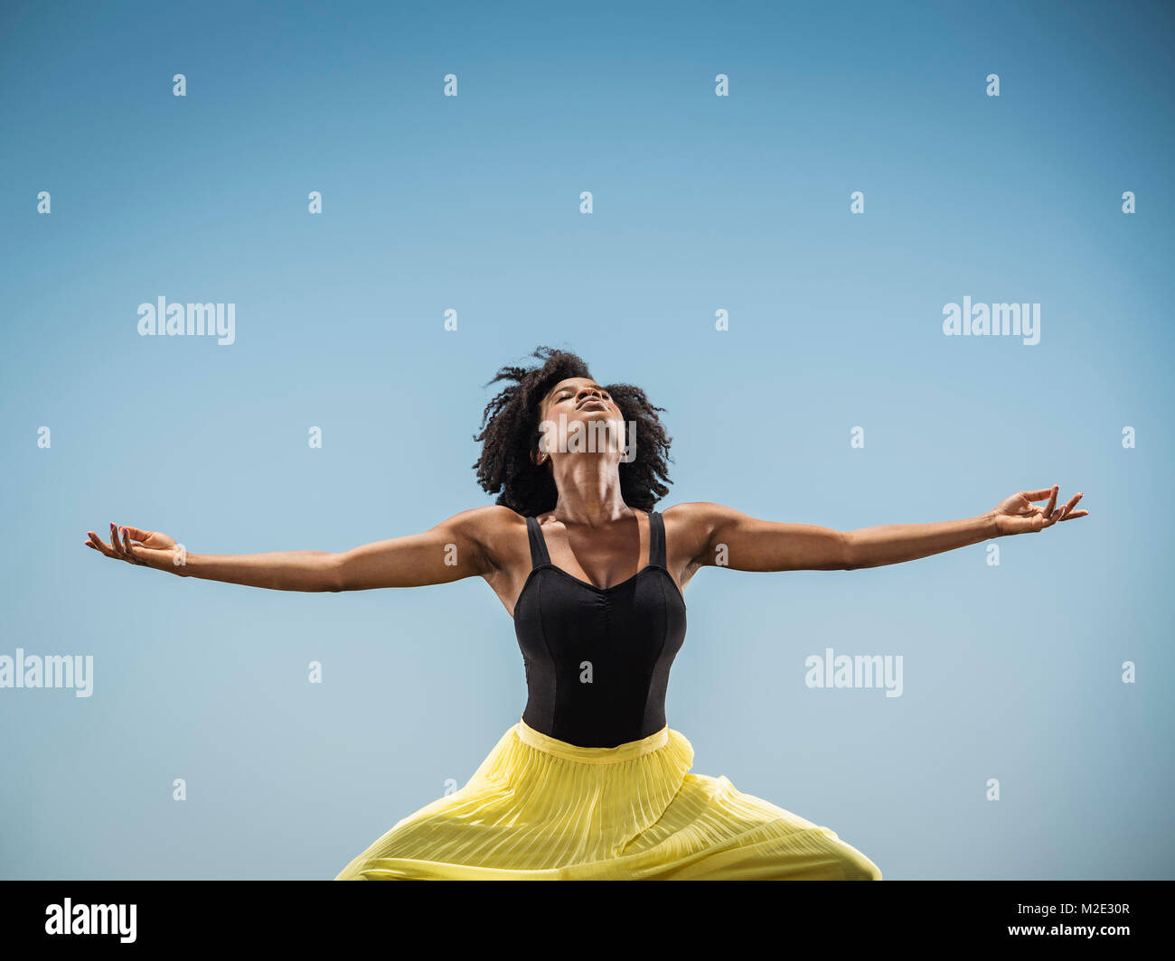 Black woman dancing with arms outstretched Stock Photo