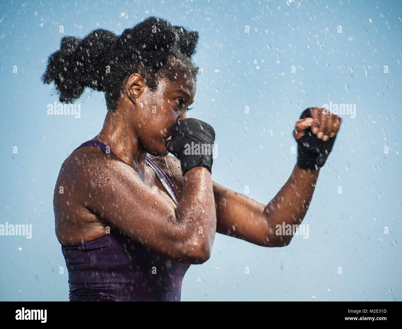 Water splashing on sparring Black woman Stock Photo