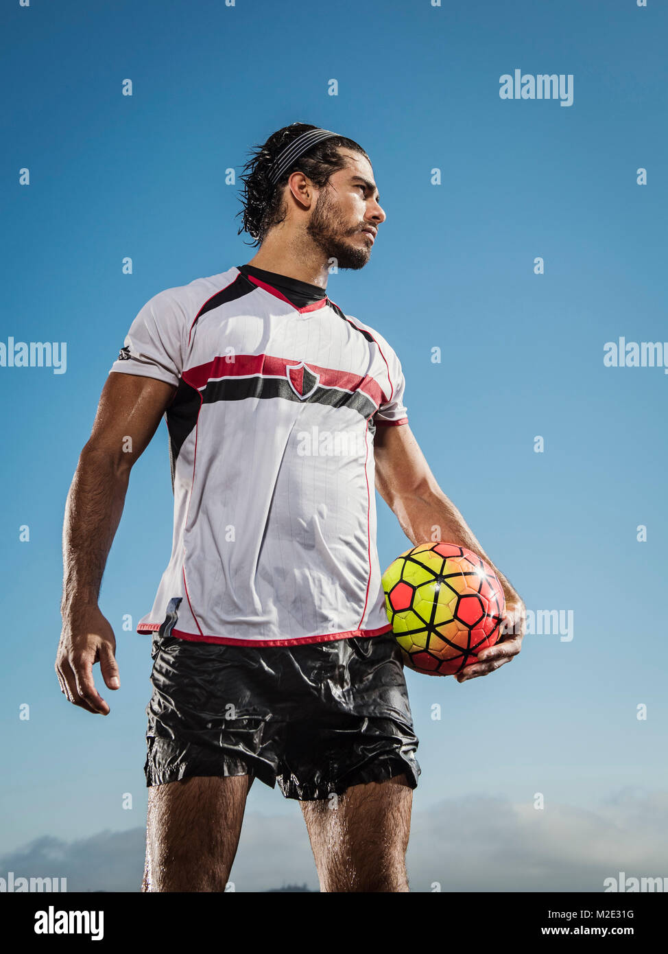 Hispanic man holding soccer ball Stock Photo