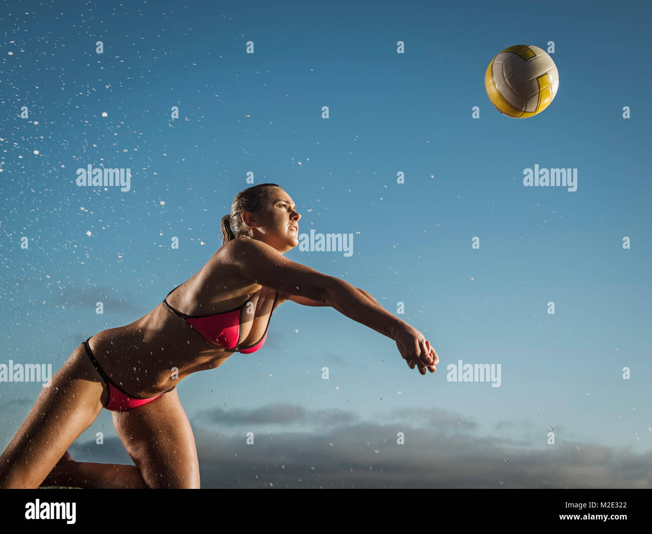 Caucasian woman diving to volleyball Stock Photo