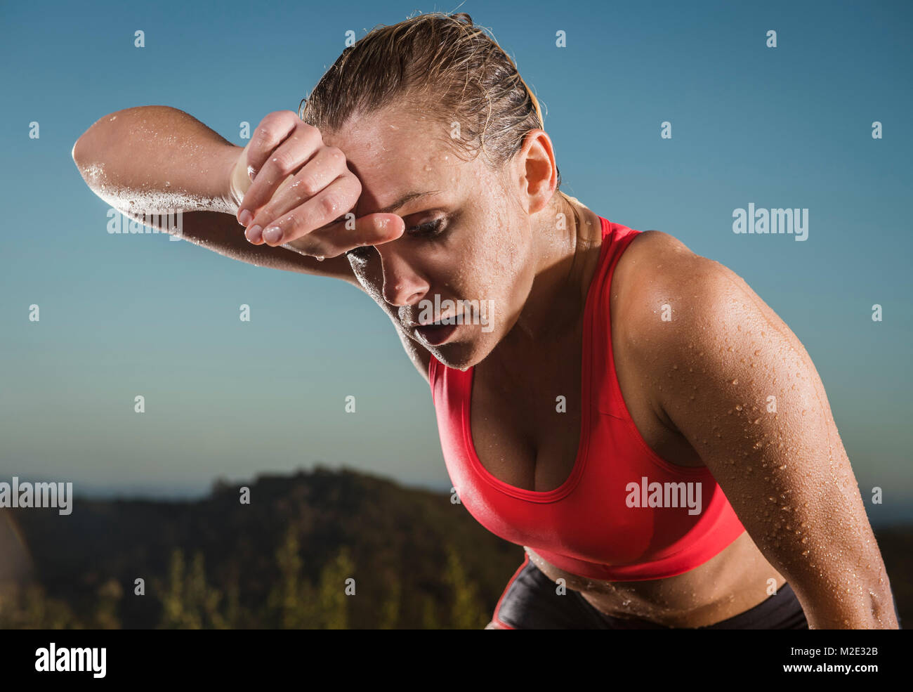 Caucasian woman wiping sweat from forehead Stock Photo