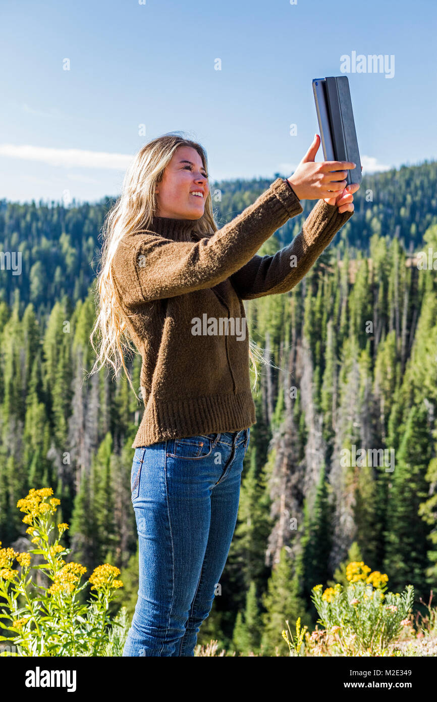 Caucasian girl photographing landscape with digital tablet Stock Photo