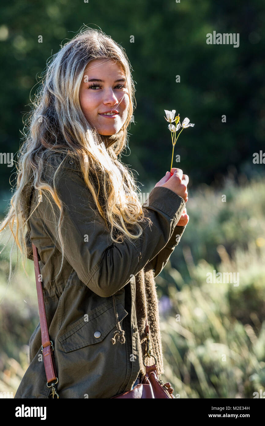 Portrait of smiling Caucasian girl holding wildflower Stock Photo