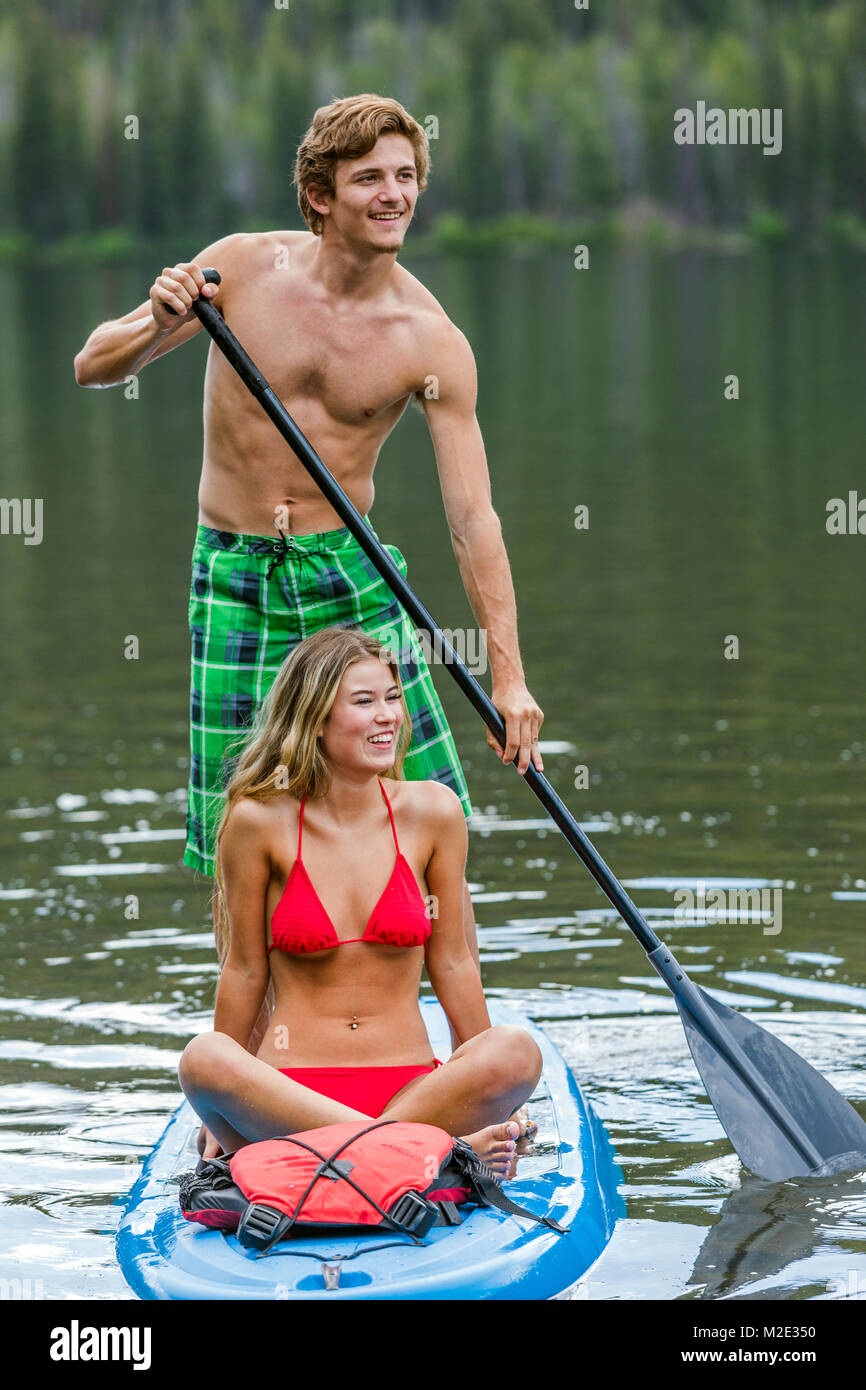 Caucasian couple riding paddleboard Stock Photo