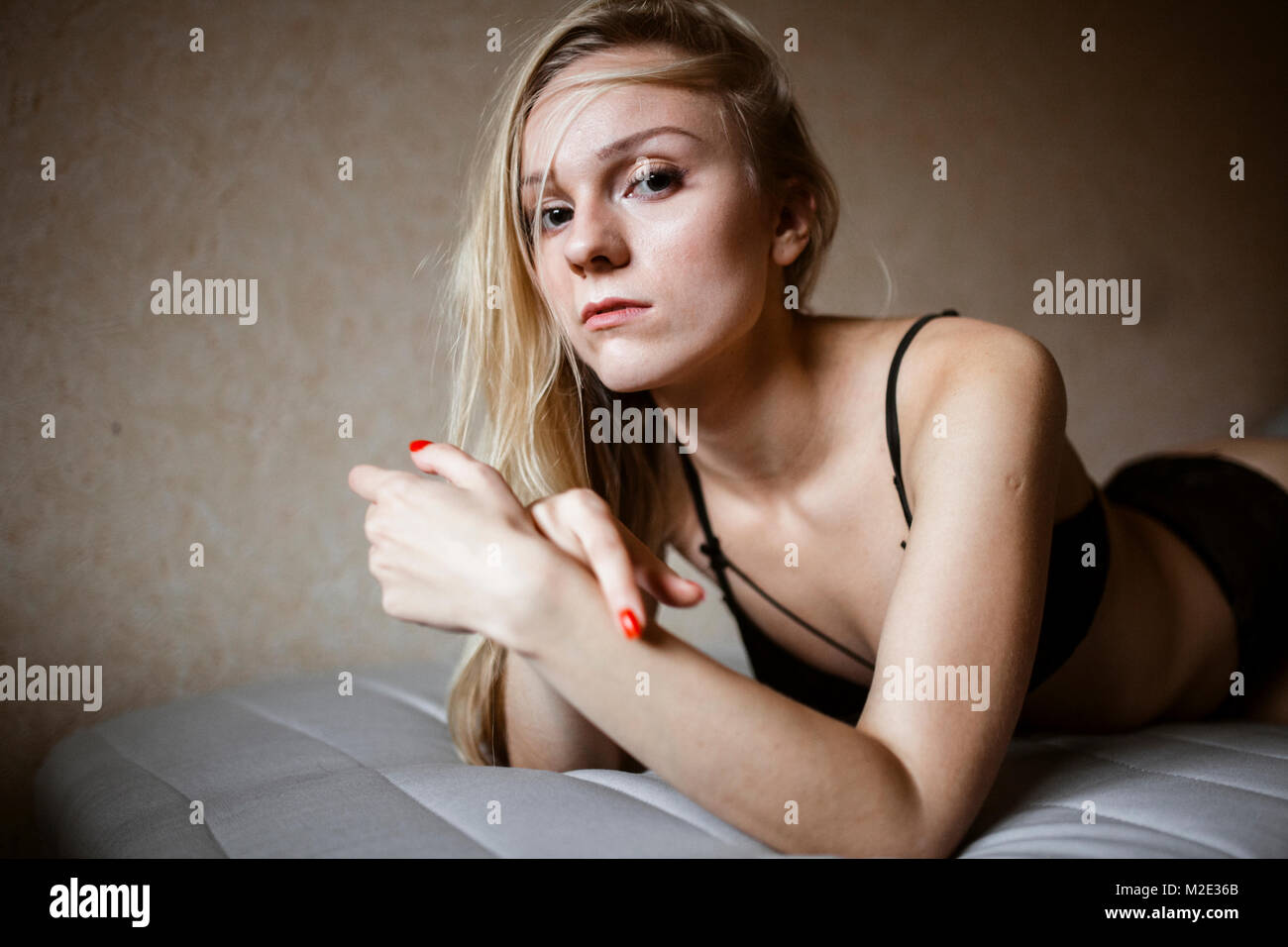Close up of serious Caucasian woman resting on bed Stock Photo
