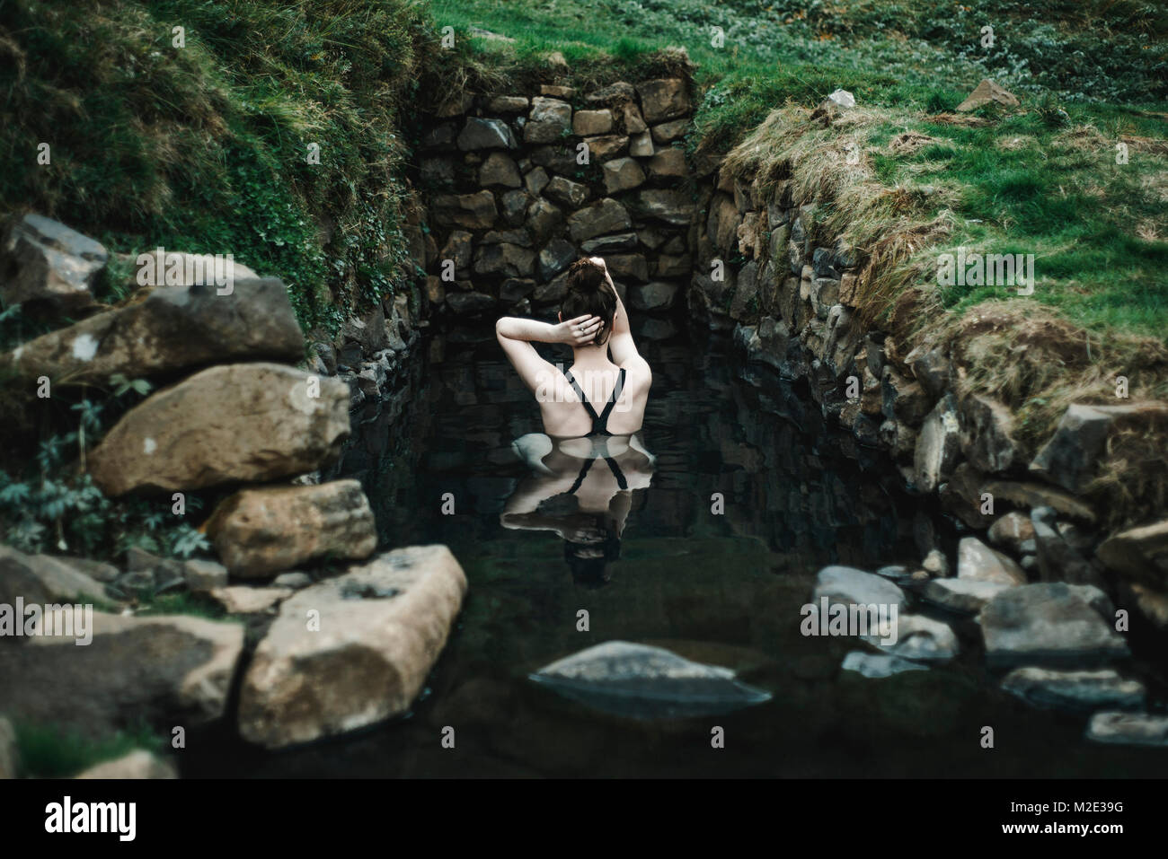 Caucasian woman swimming in pond Stock Photo