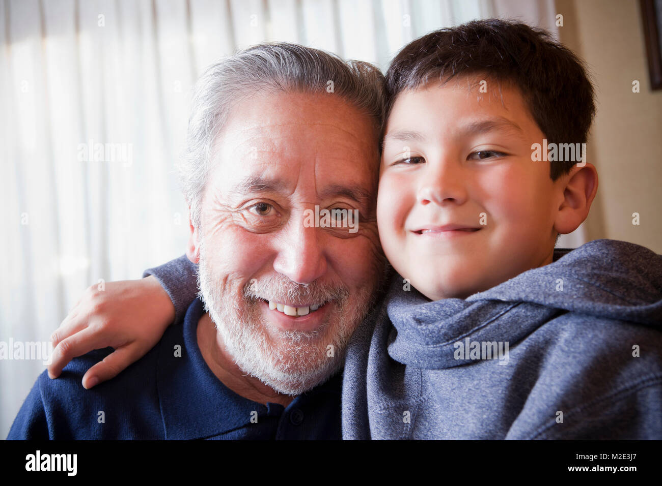 Hispanic grandfather and grandson hugging Stock Photo
