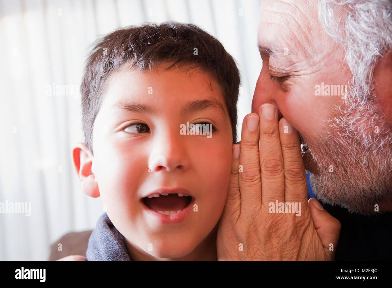 Hispanic Grandfather Whispering Secret To Grandson Stock Photo Alamy