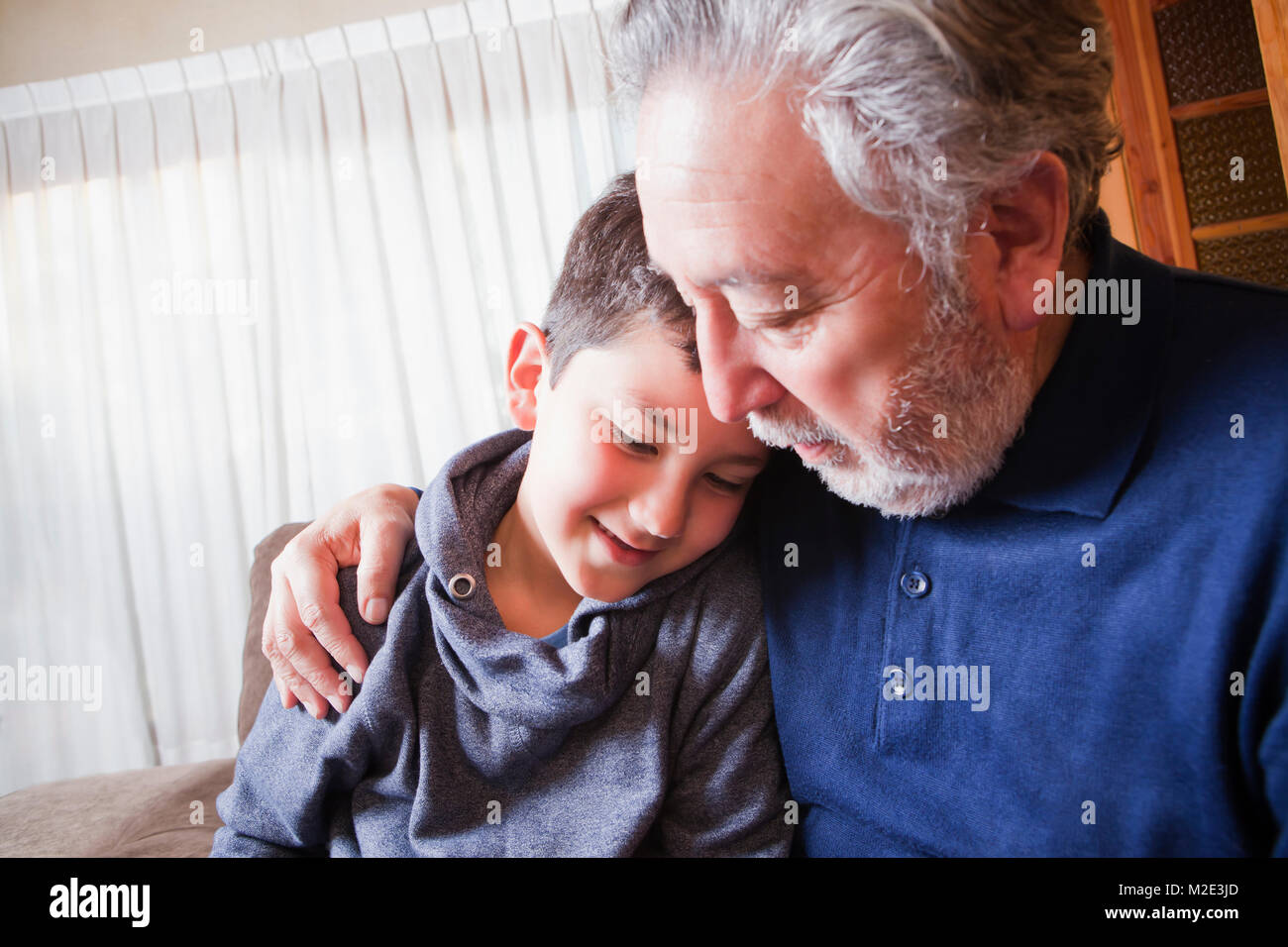 Hispanic grandfather hugging grandson Stock Photo