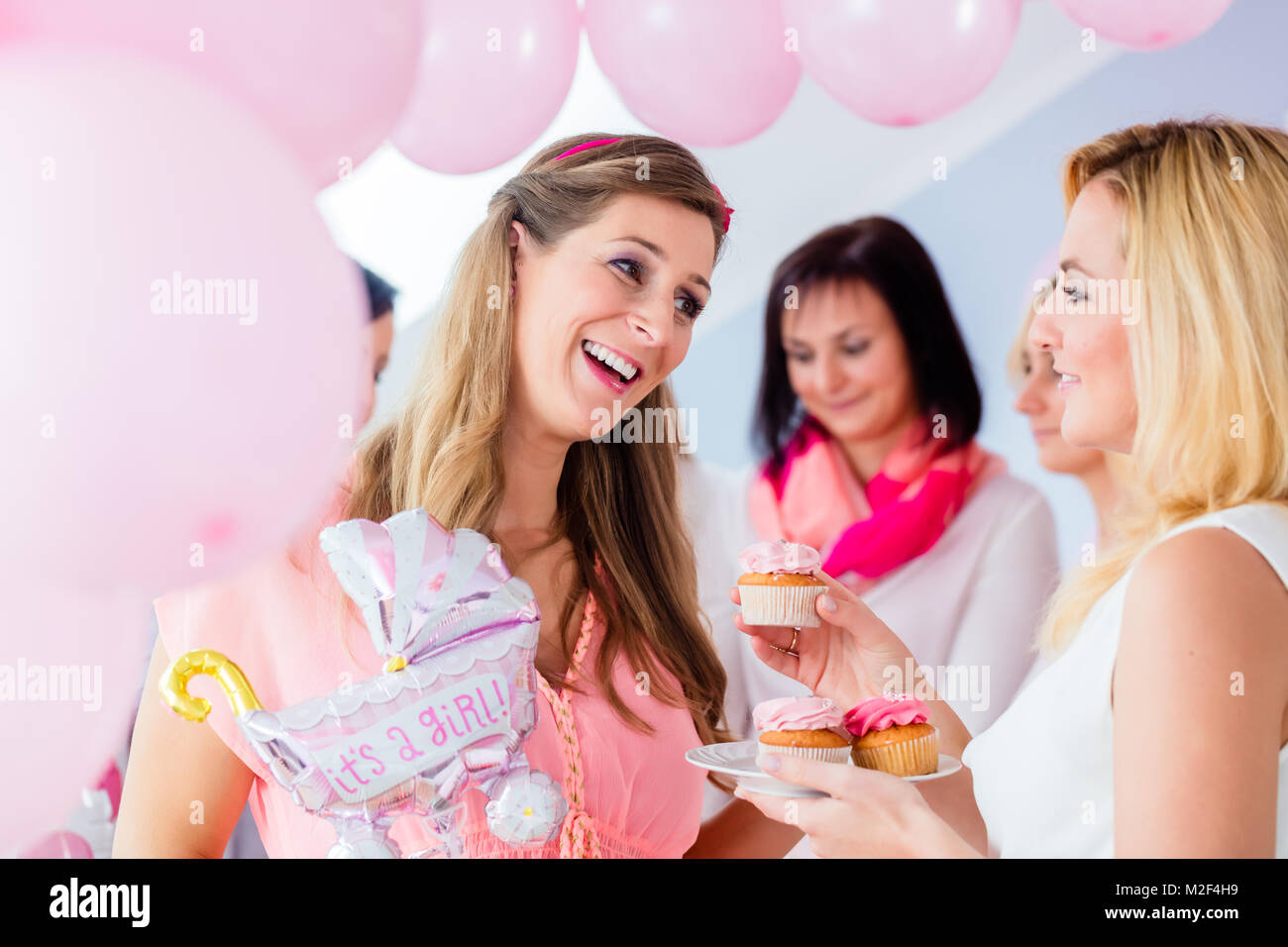 Expecting mother eating cupcake on baby shower party Stock Photo