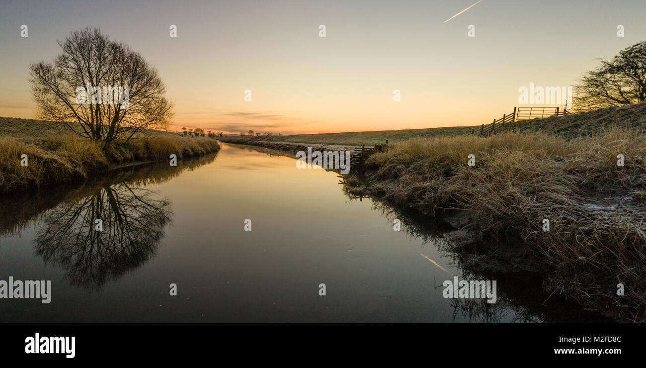 Great Eccleston, UK. 7th February 2018. UK Weather: Drone captures sunrise over the River Wyre.  The frosty river bank can be seen on each side. Credit: Russell Millner/Alamy Live News Stock Photo
