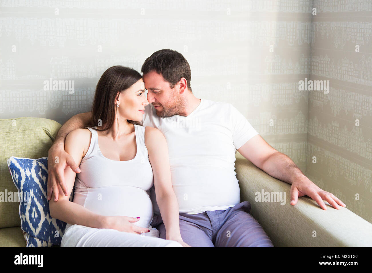 Pregnant woman and young man together indoors Stock Photo - Alamy