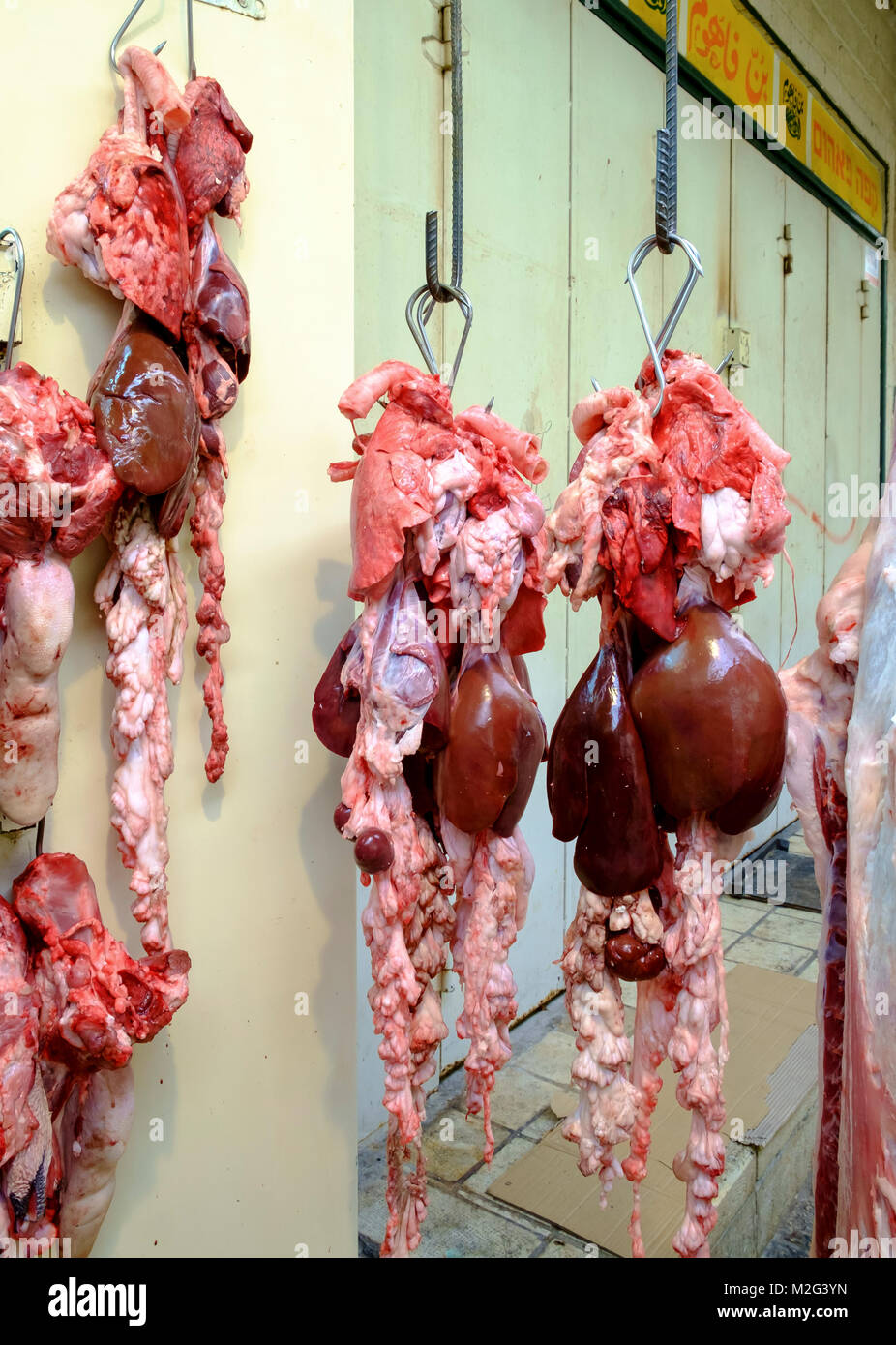 Fresh Meat hanging from a rack in a small family run Butcher shop. Photographed in Nazareth, Israel Stock Photo