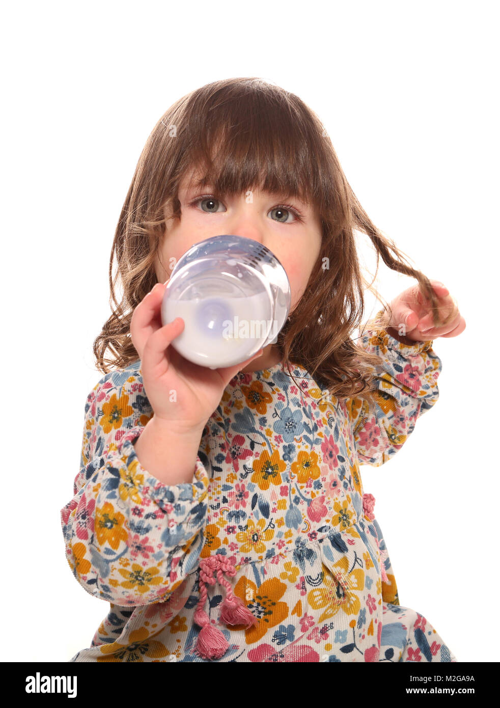 toddler girl drinking milk from a bottle Stock Photo