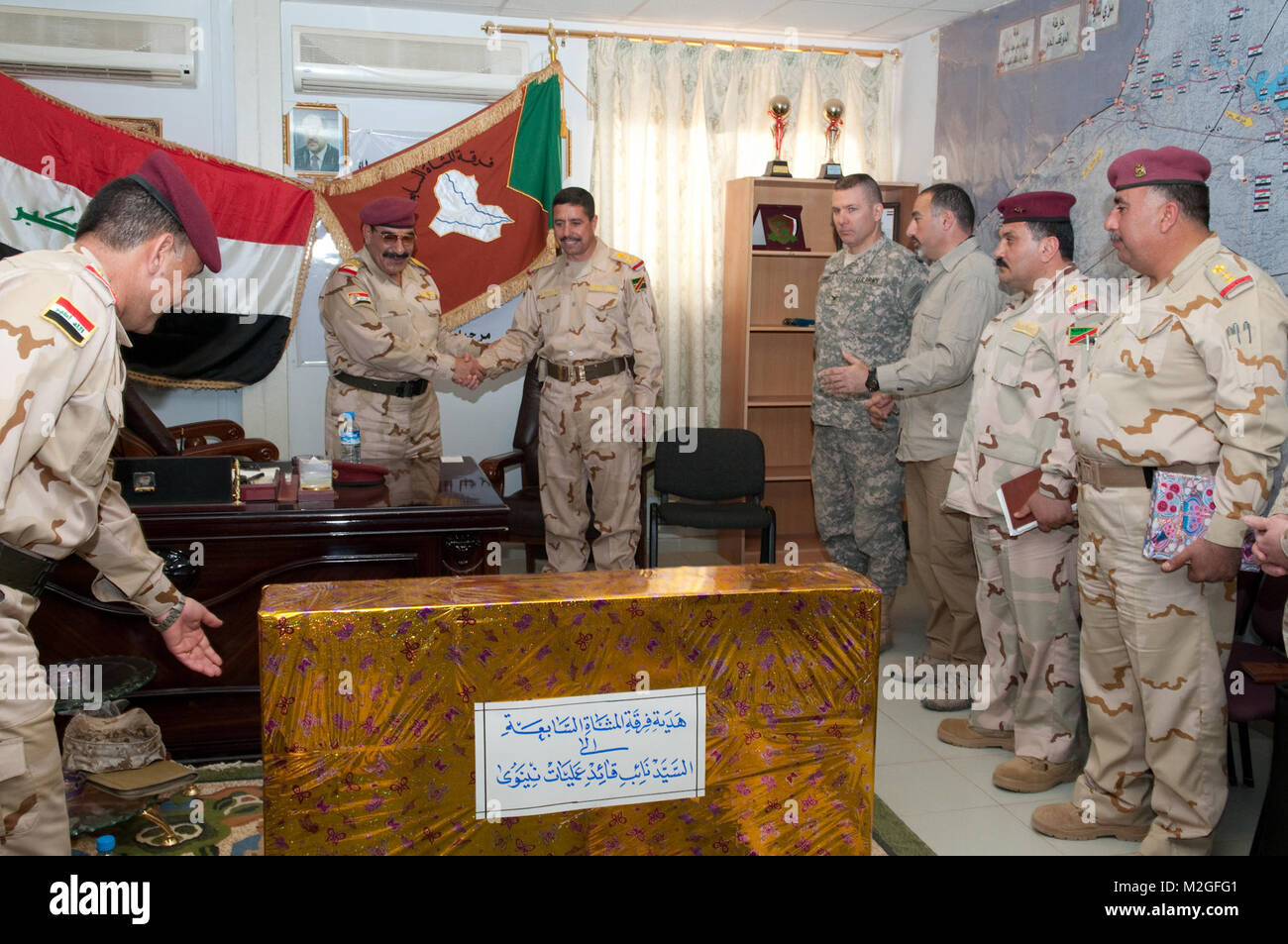 Staff Maj. Gen. Abdullah Muhammad Baider Aljubouri, outgoing commander of the 7th Iraqi Army Division, shakes the hand of his replacement, staff Brig. Gen. Ismaeel Khalif al-Khalifawi, before a gift from the 7th Division April 1, 2010, Camp Mejid, Iraq. Abdullah commanded the 7th Division during some of Al Anbar province’s most dramatic security gains since the 2003 invasion of Iraq. (U.S. Army photo by Sgt. Michael J. MacLeod, 1/82 AAB, USD-C) Shaking hands with his replacement by 1st Armored Division and Fort Bliss Stock Photo