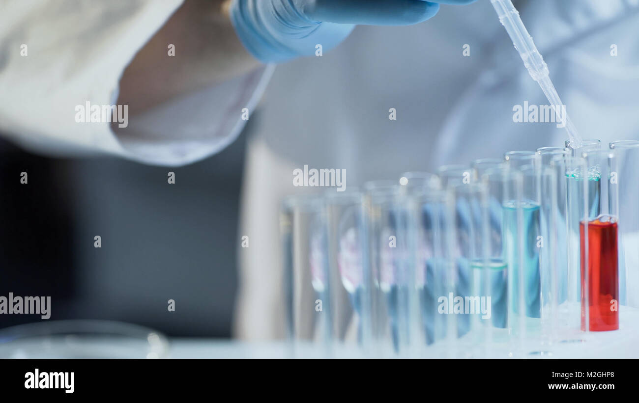 Lab worker adding concentrate to different reagents to follow reactions