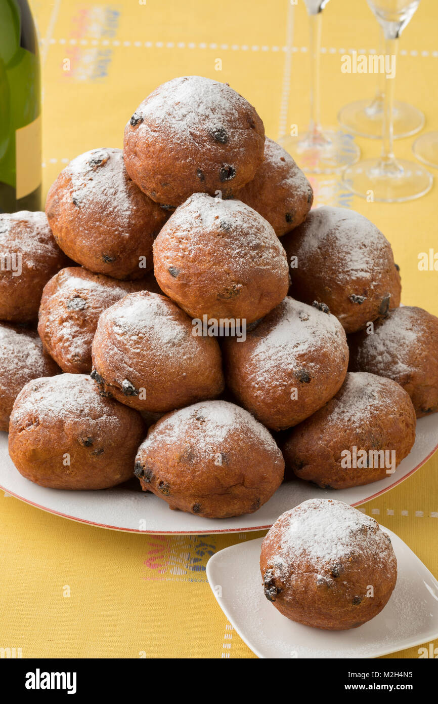 Dish with oliebollen covered with sugar, traditional Dutch pastry for