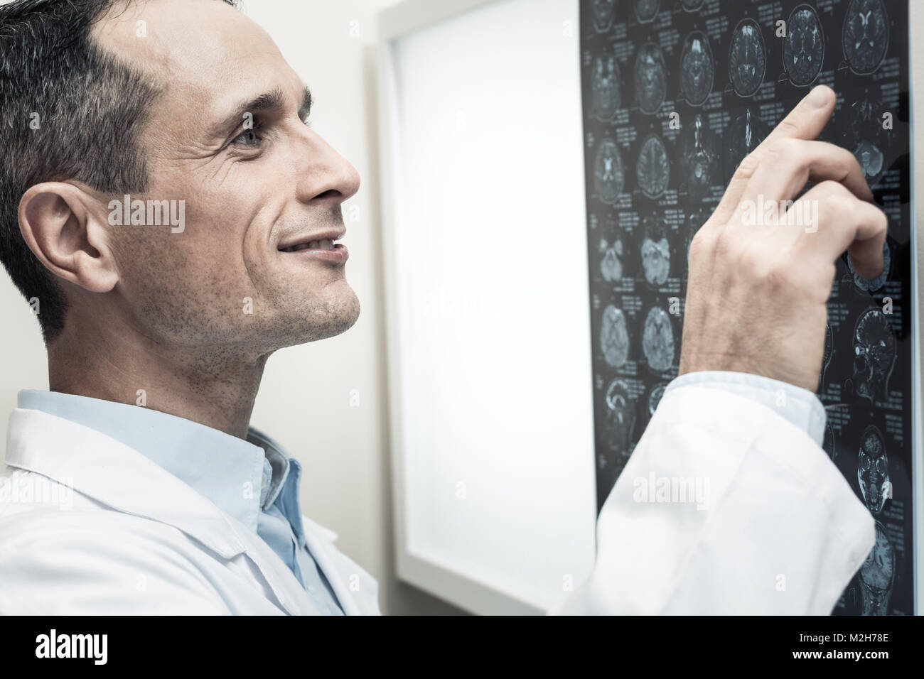 Nice professional neurologist looking at the X ray scan Stock Photo