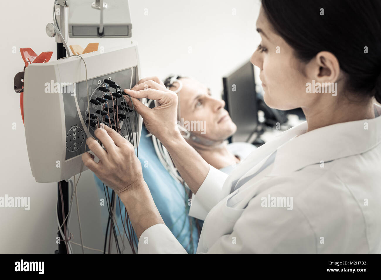 Professional nice doctor setting up the electroencephalograph Stock Photo
