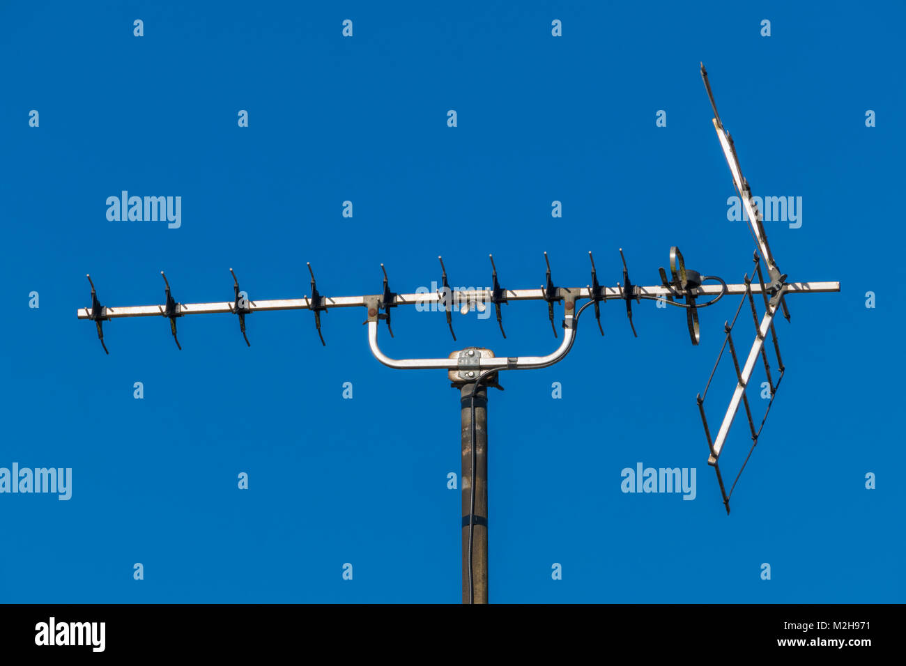 Closeup view of a traditionall roof aerial / antenna for television TV sound and viewing signal, against a blue sky. England, UK. Stock Photo