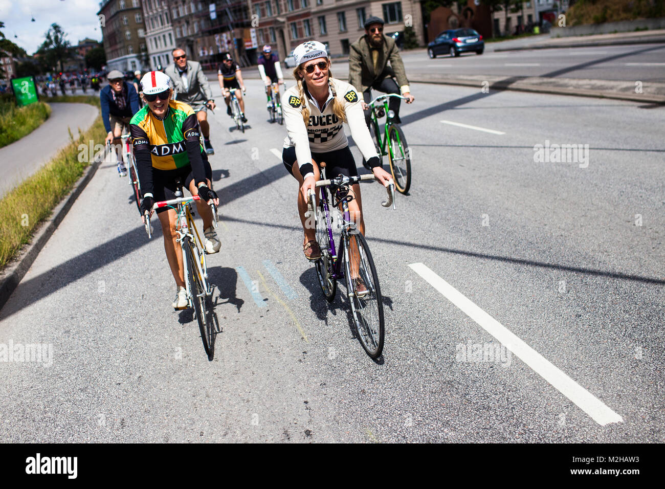 Two cyclers in classical bike tricots lead the vintage bike event Copenhagen Classico 2014. Denmark, 22/06 2014. Stock Photo