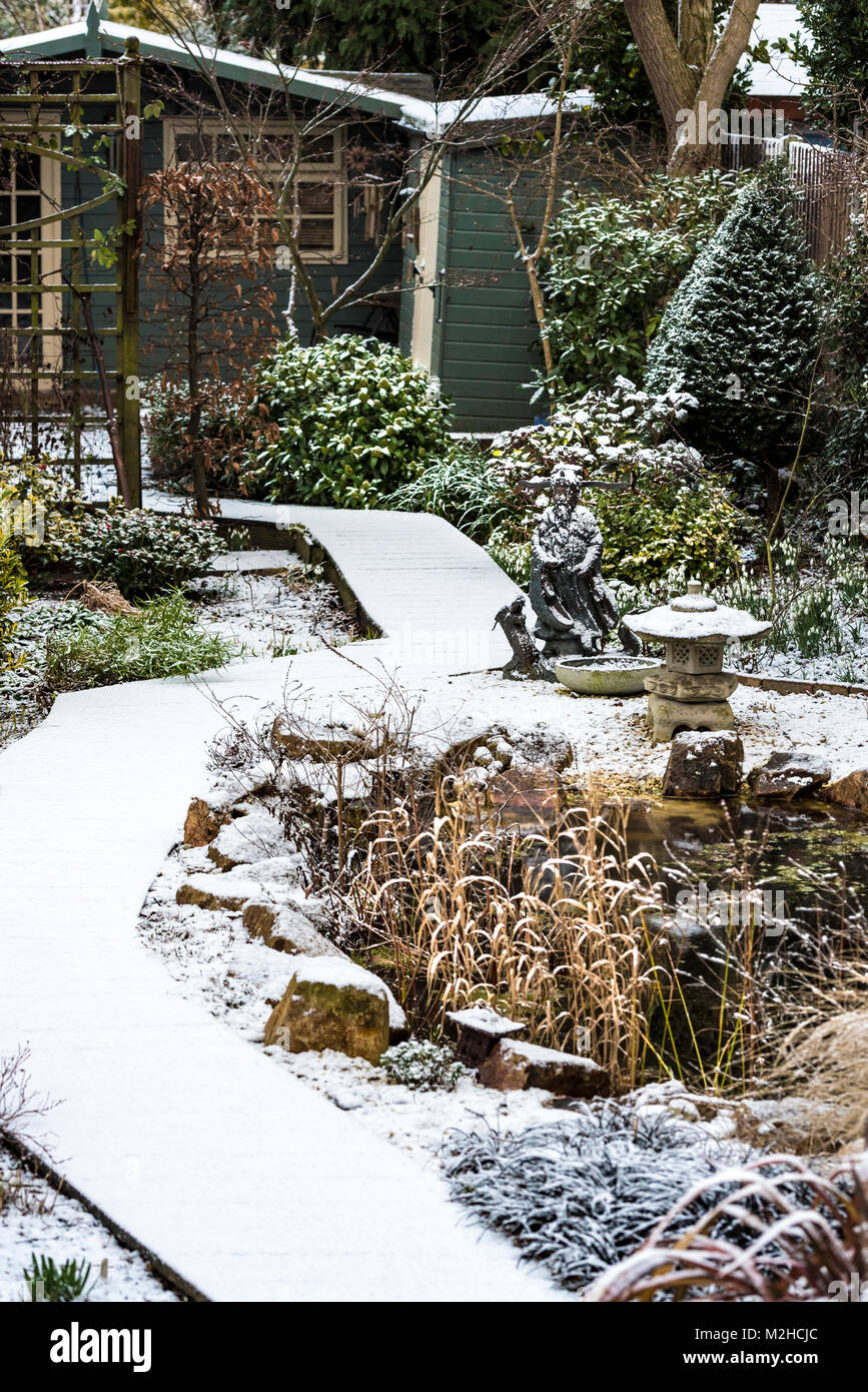 Light snow covering on a landscaped English surburban garden. Stock Photo
