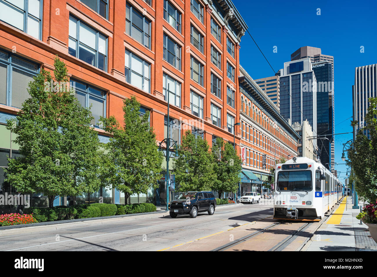 RTD light rail train and car moves along California Street in downtown Denver Colorado USA. Stock Photo
