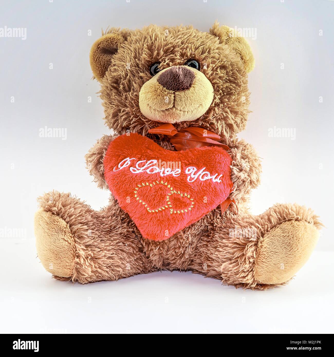Teddy Bear Holding a  Red Heart. Isolated. Stock Photo