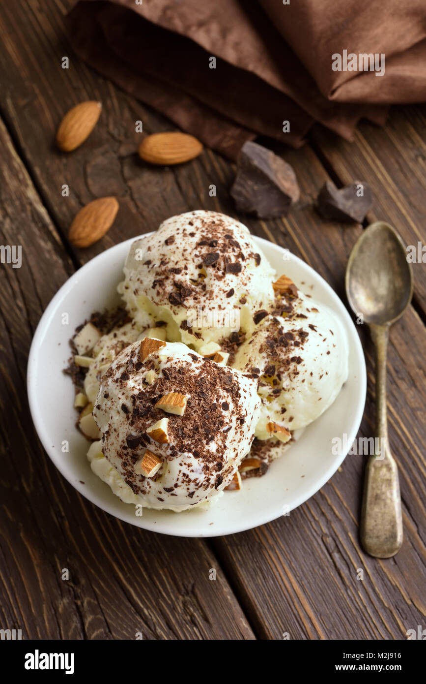 Summer dessert. Scoops of vanilla chocolate ice cream with nuts in bowl