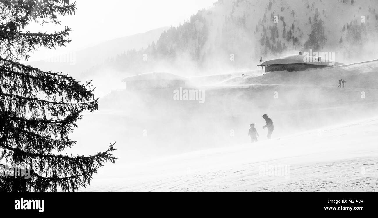 Hikers ski in poor visibility due to a snowstorm in the South Tyrolean mountains at winter time. Italy Stock Photo