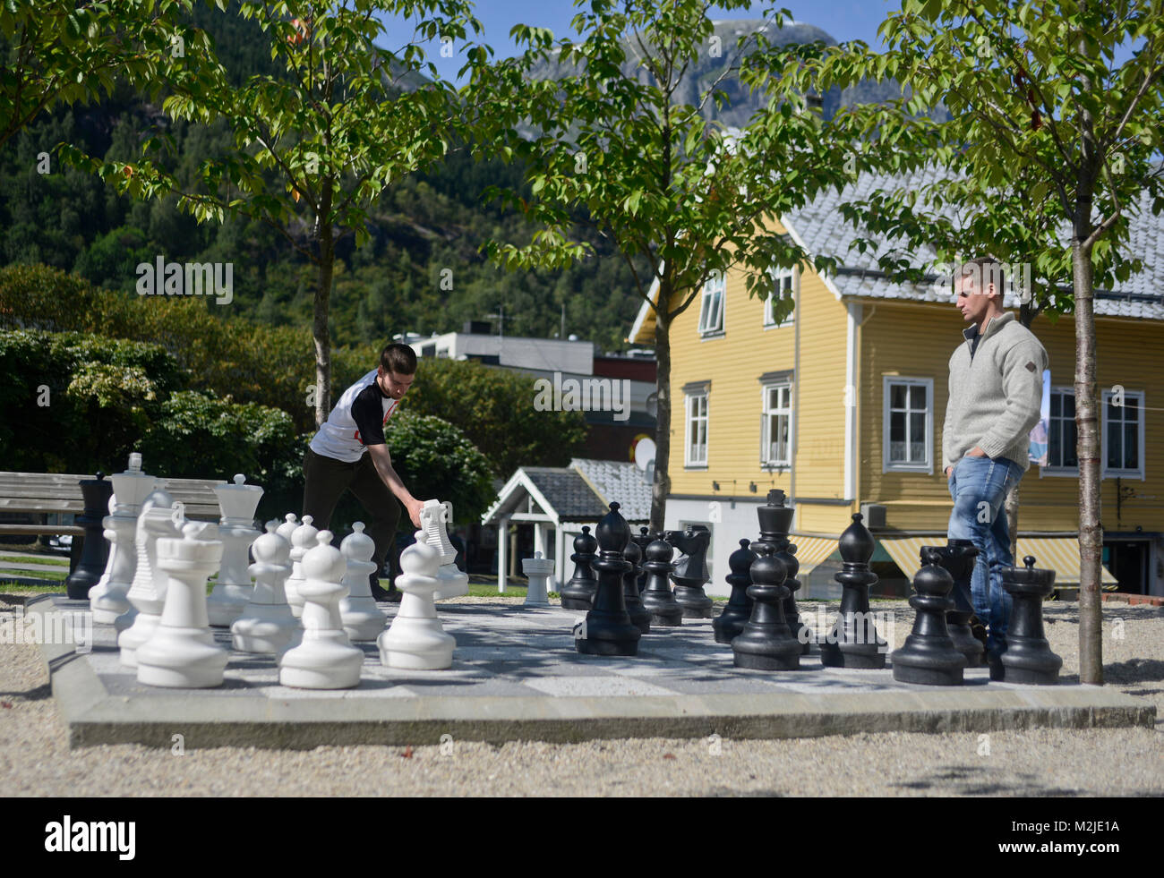 Two friends playing chess on a giant chess board, Odda, Norway Stock Photo