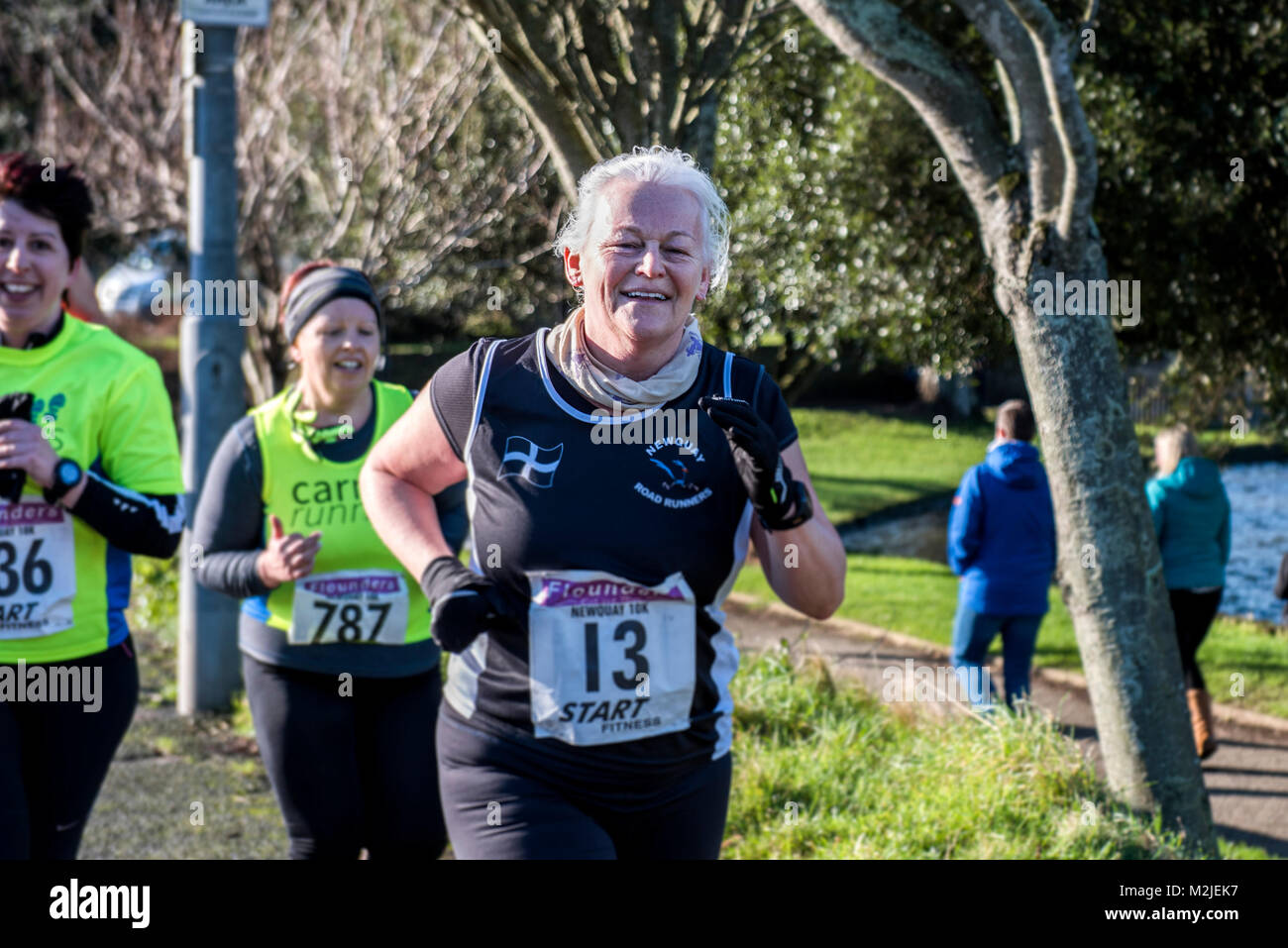 A mature female runners competing in a road race in Newquay Cornwall. Stock Photo
