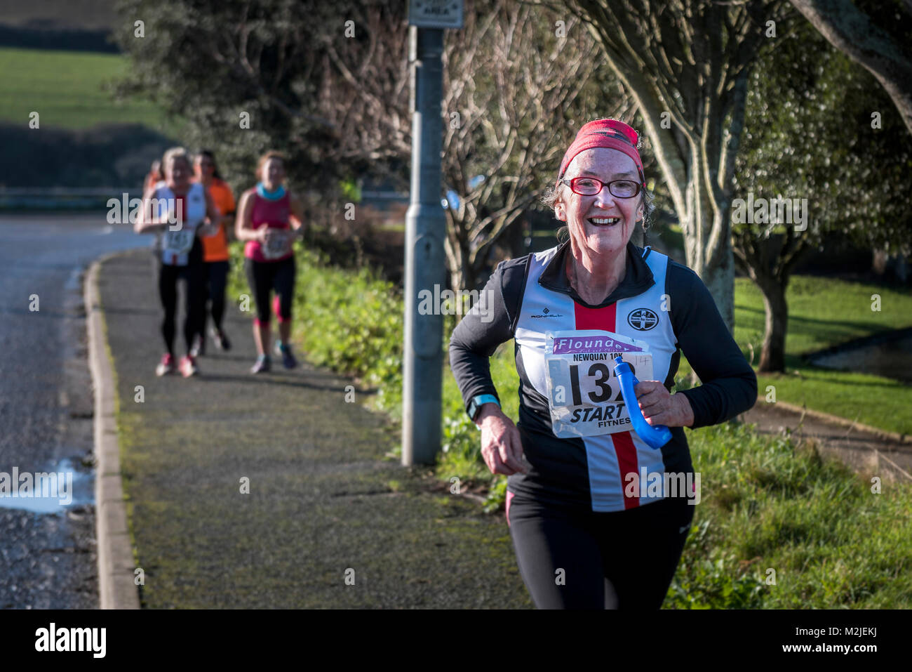 A mature female runner competing in a road race in Newquay Cornwall. Stock Photo