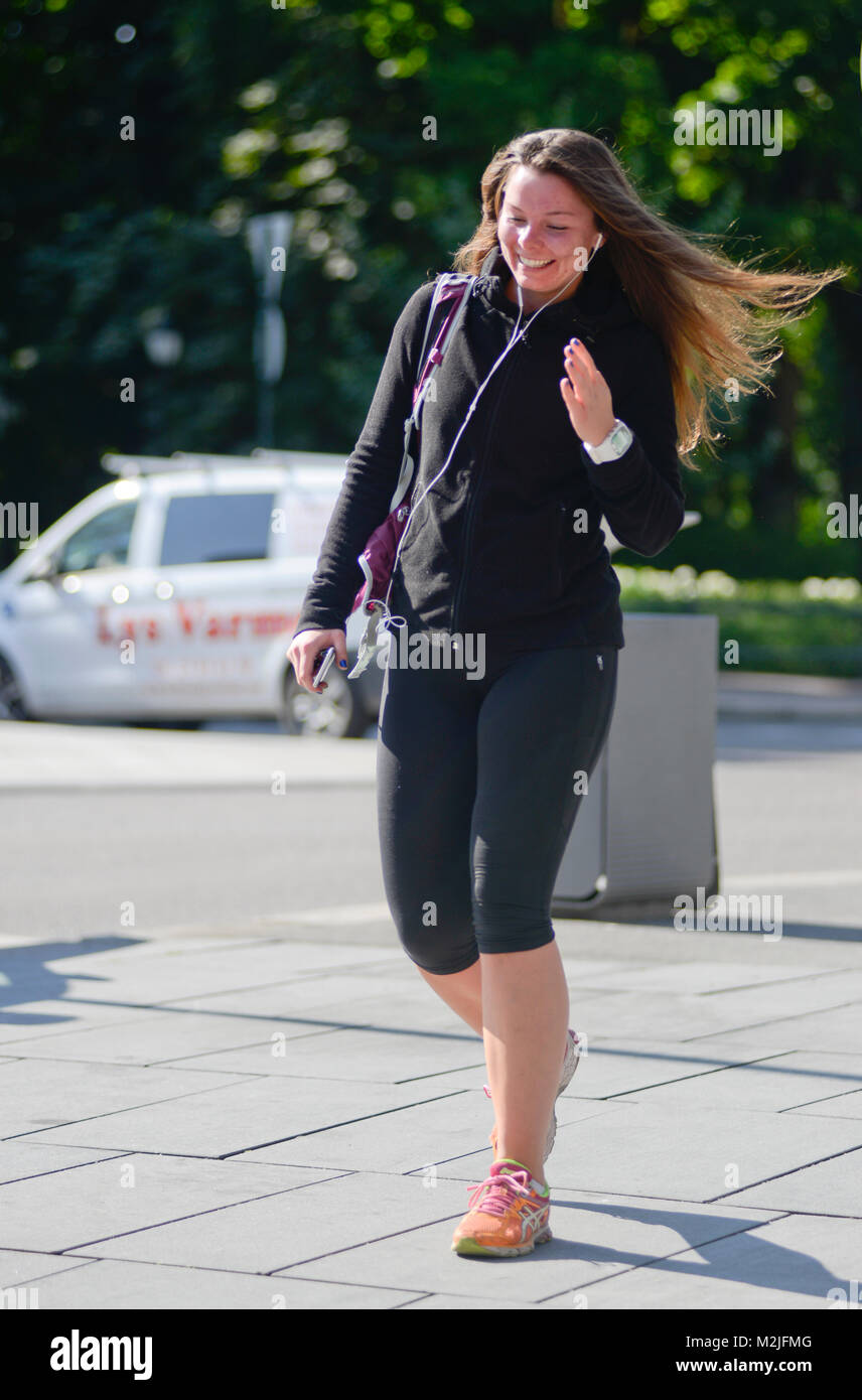 Smiling woman walking down Parkveien street, Oslo (Norway) Stock Photo