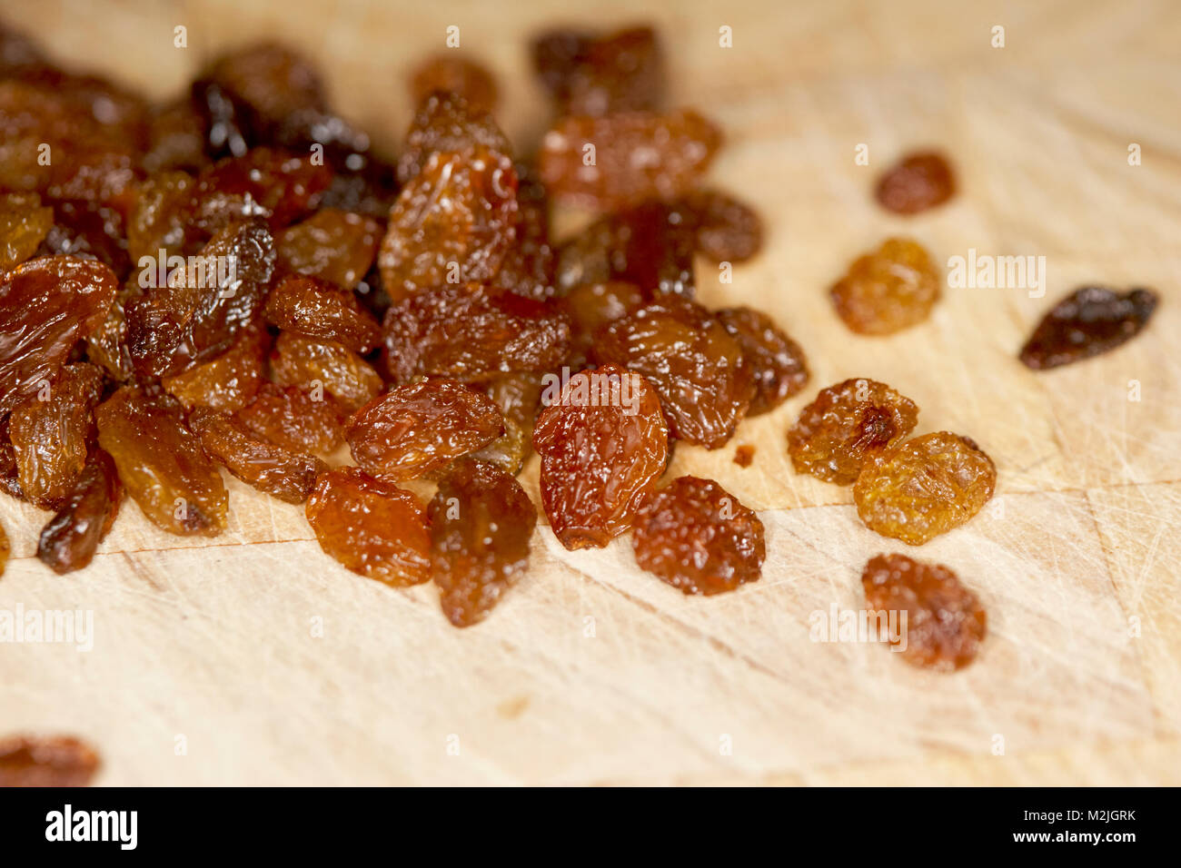 sultanas on a wooden board for inclusion in a baking recipe Stock Photo