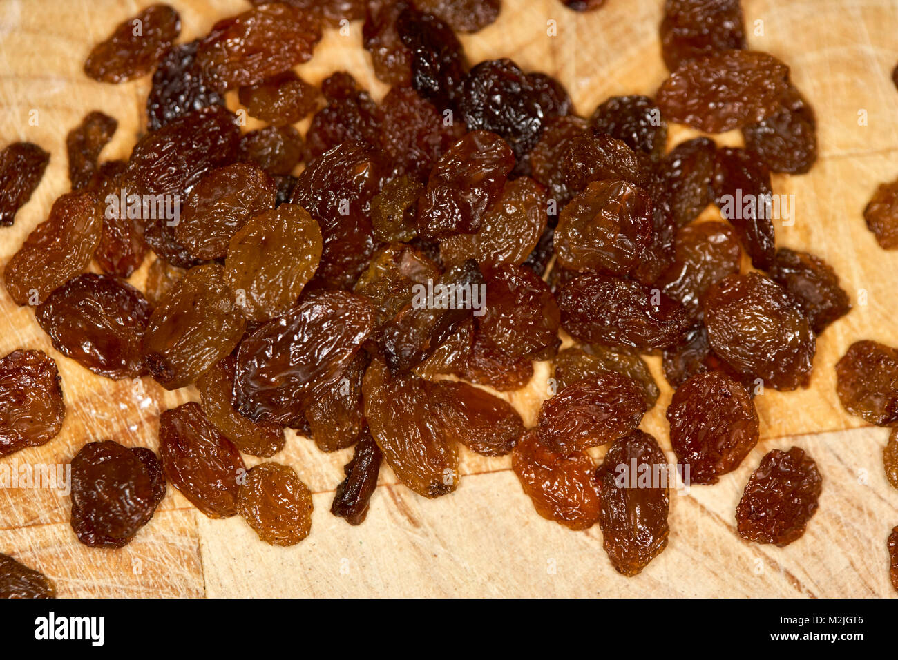 sultanas on a wooden board for inclusion in a baking recipe Stock Photo