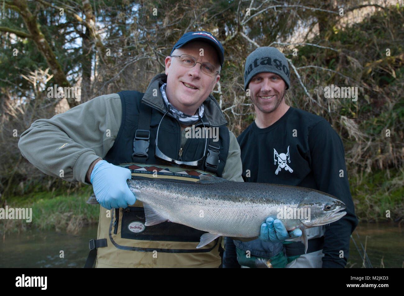 Steelhead trout fishermen with a hatchery bred Siletz river steelhead caught on a guided float trip. Model releases, editorial use only. Stock Photo