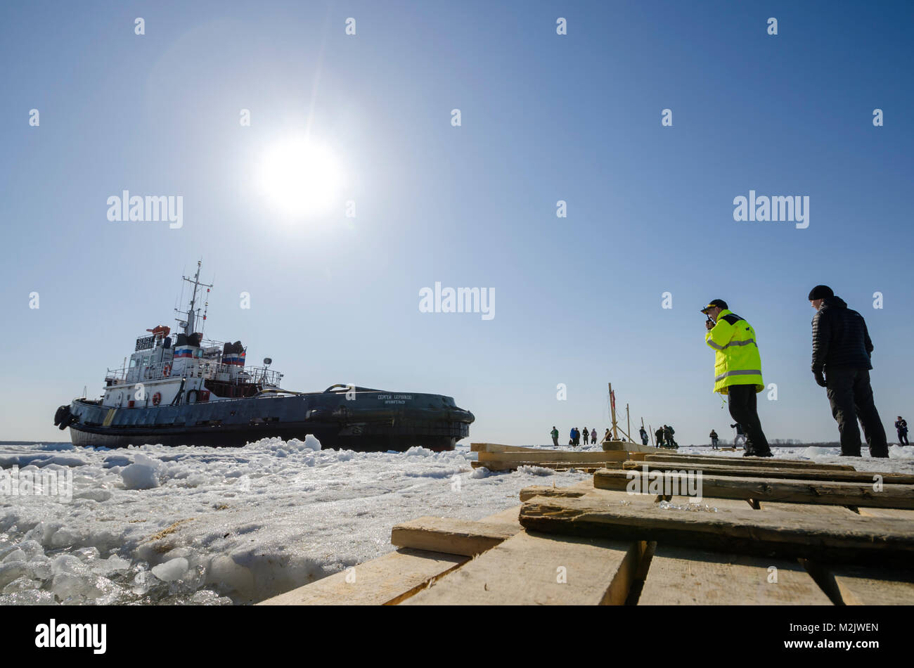 Icebreaker walking along the river past the pedestrian ice crossing Stock Photo