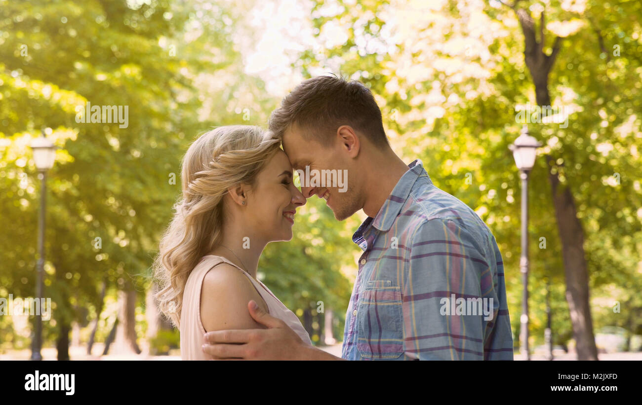 Couple In Love Gently Embracing Enjoying Each Other On Date In Park