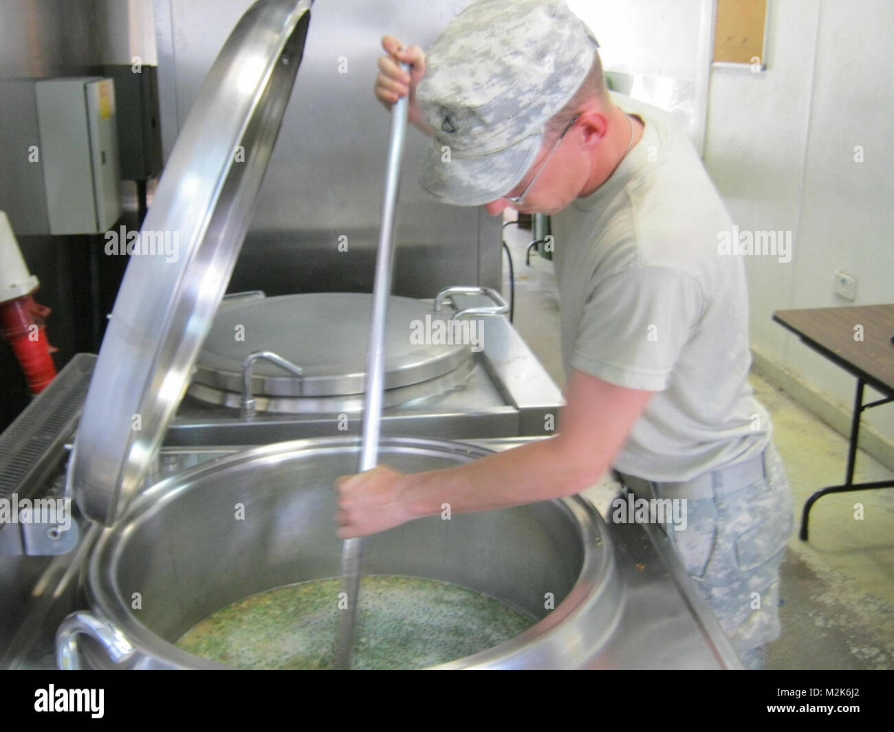 Pfc. Daniel Summey a food service specialist with Forward Support Company, 215th Brigade Support Battalion, 3rd Advise and Assist Brigade, 1st Cavalry Division and a native of Charlotte, N.C., stirs a giant pot as he heats up food for hungry soldiers at Contingency Operating Station Garry Owen, Iraq, Sept. 19. Hungry soldiers by United States Forces - Iraq (Inactive) Stock Photo