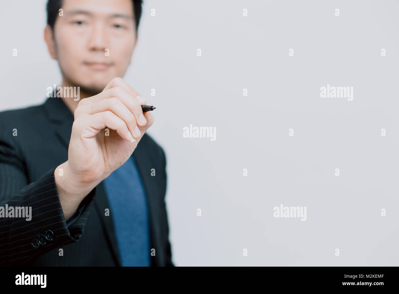 Asian business man with pen write his idea on board Stock Photo