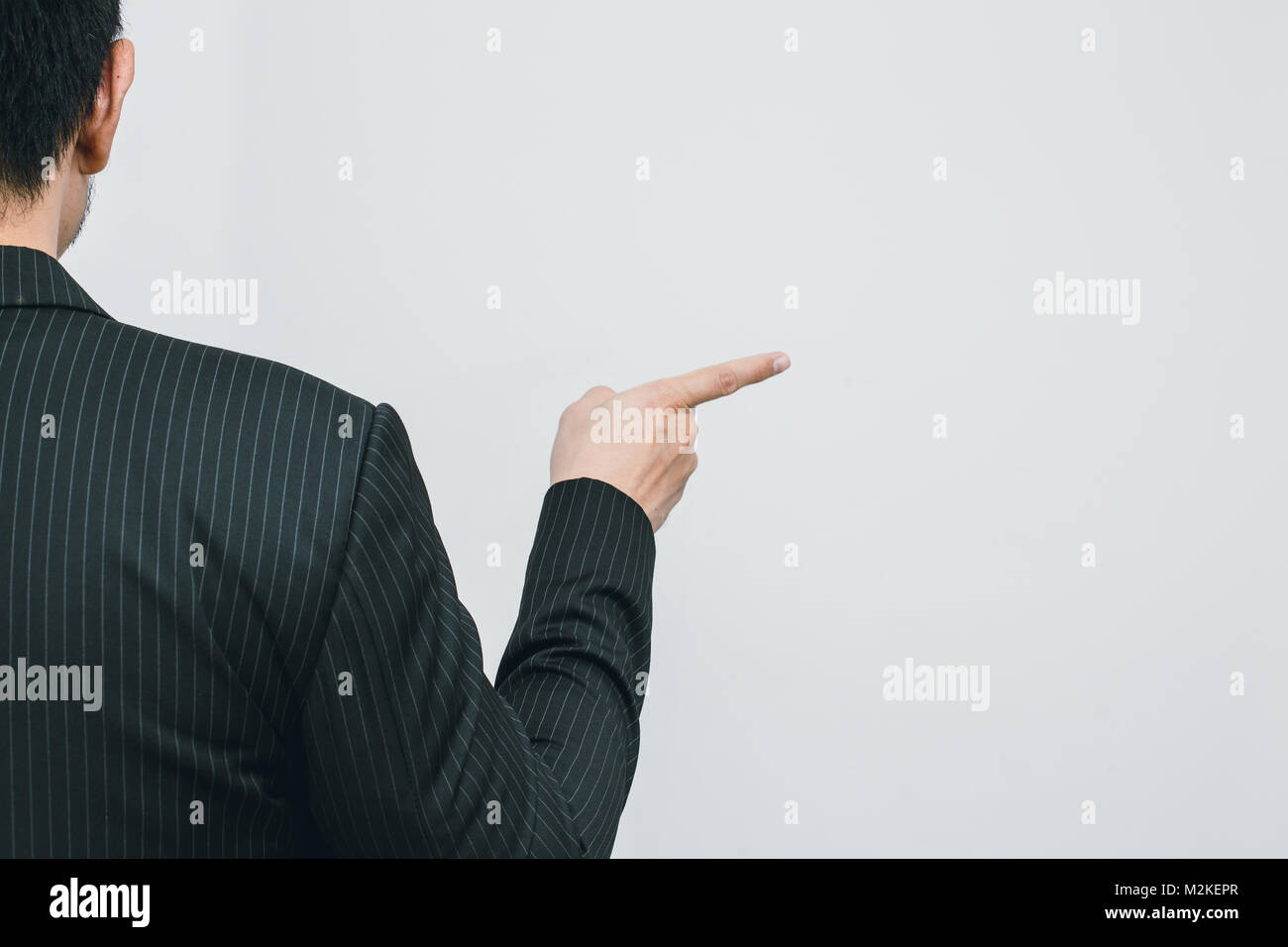 Asian business man pointing his finger to touch or order command back view on white space Stock Photo