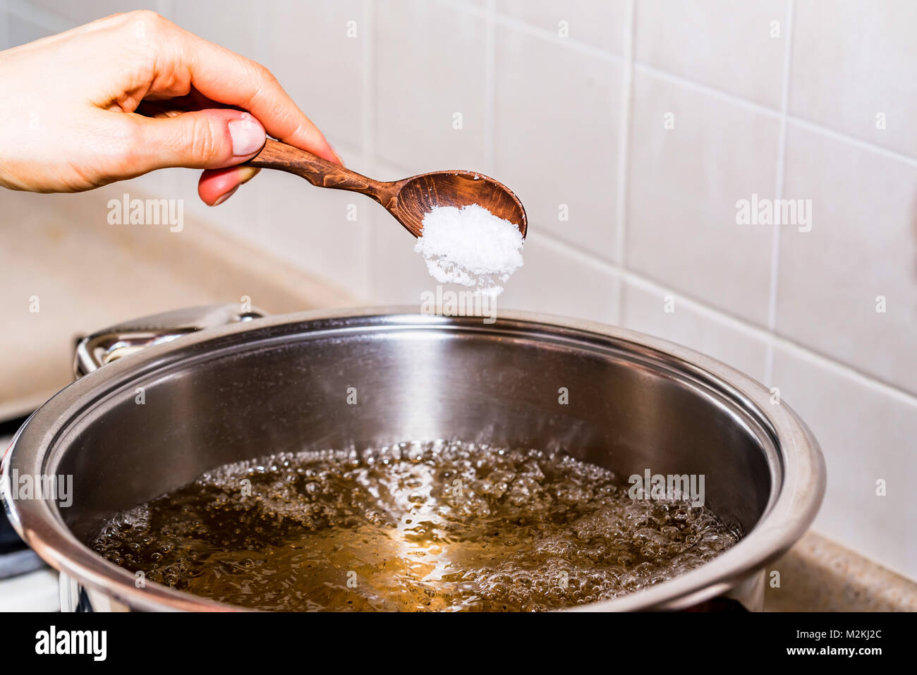 Adding salt in boiling water, cooking soup Stock Photo Alamy