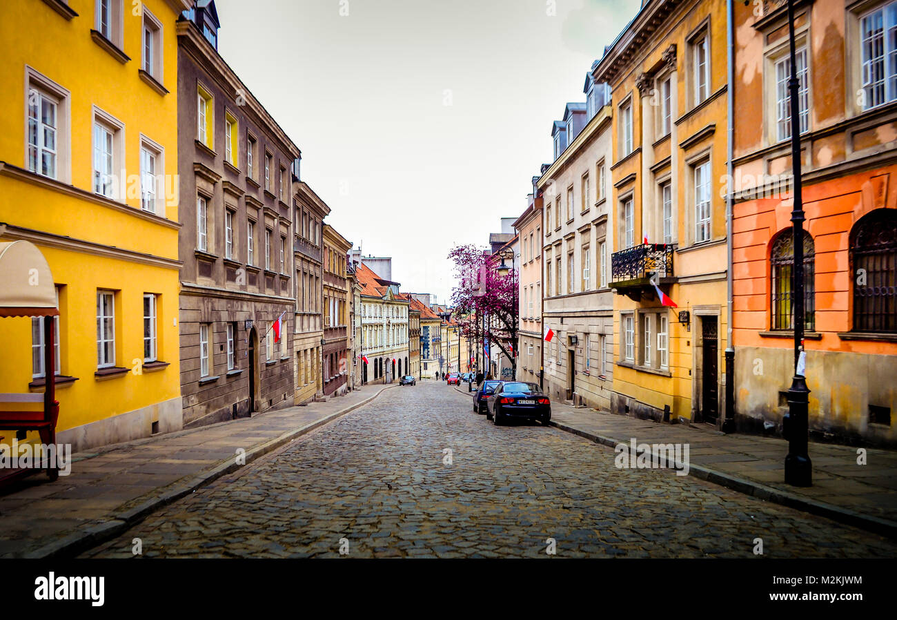 View of a cobble stone street with symmetrical houses on both sides in old city center of Warsaw in Poland Stock Photo