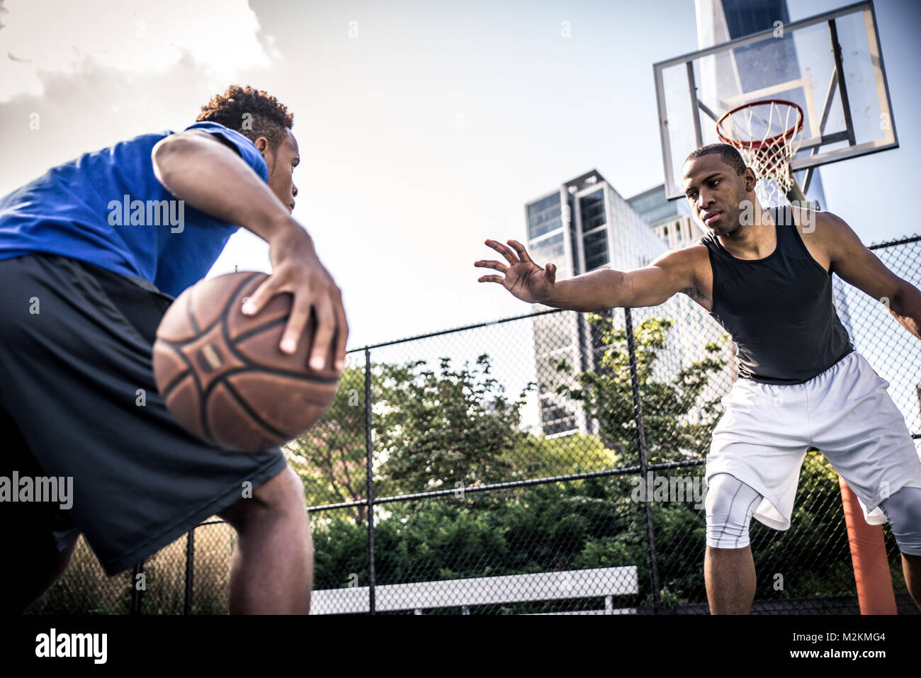 Two street basketball players playing hard on the court Stock