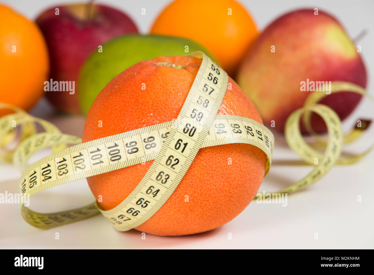 Fruits and measuring tape. Diet concept. Vegan food background. Stock Photo